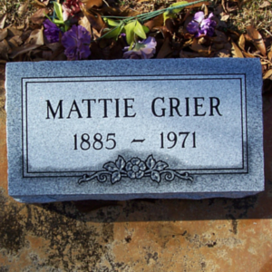 Gray marker memorial with the name Mattie Grier with floral design at the bottom frame. 